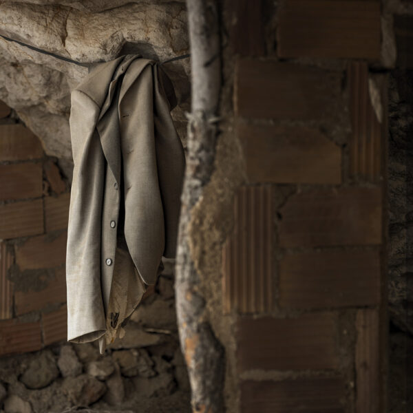 Camisa colgada en el interior de una cueva, transmitiendo un toque humano en un entorno rústico.